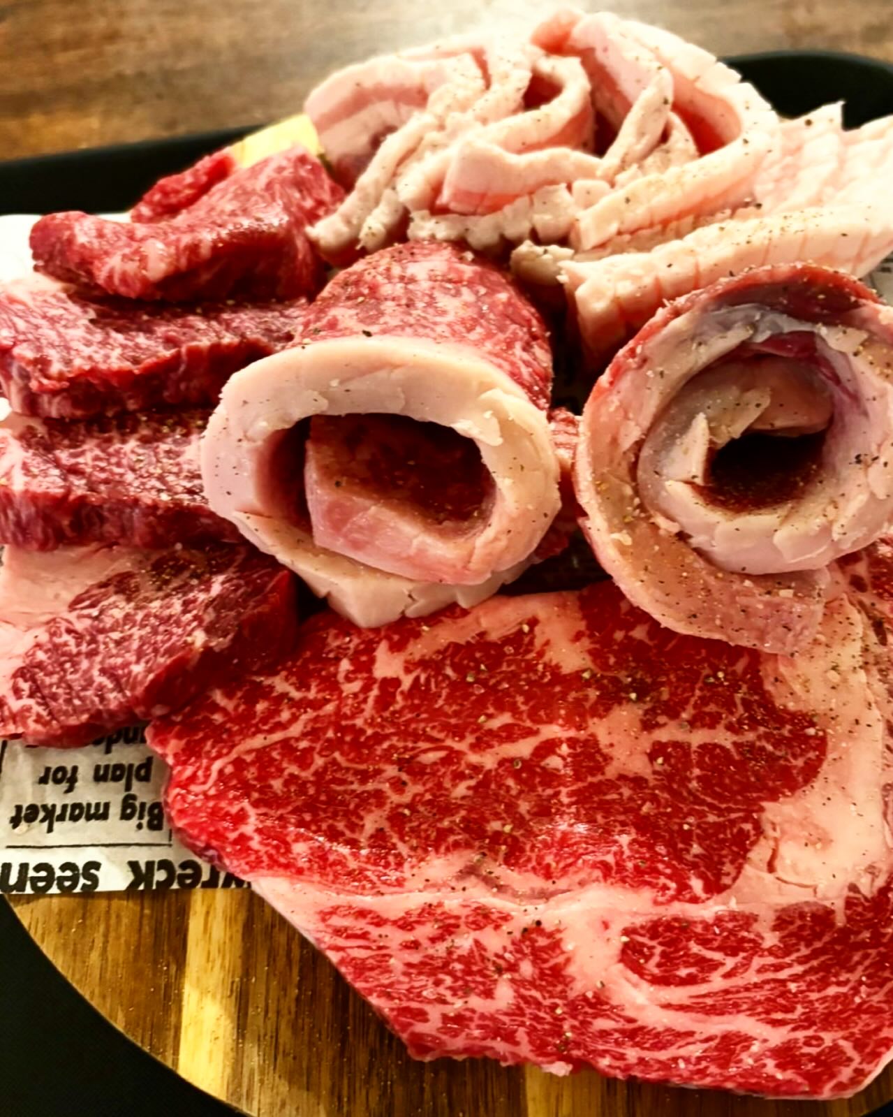 Platter of raw marbled beef and pork cuts ready for Korean BBQ
